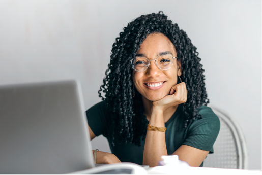 Image of a smiling woman sitting behind a laptop